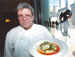 Chef Holding A Plate of Roasted Halibut With Charmoula Hummus and Green Beans