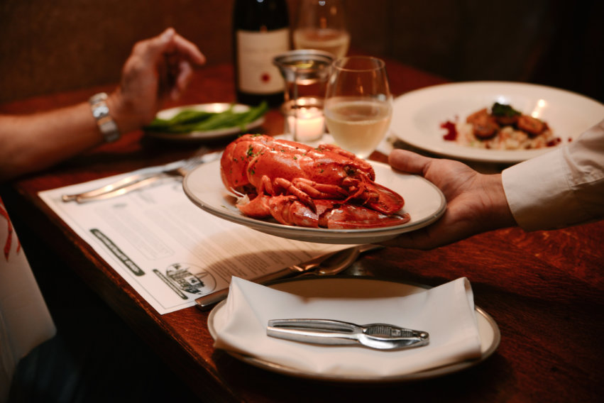 Server Handing Off A Plate With A Lobster